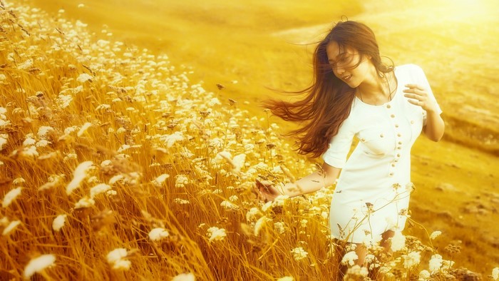 Asian woman in white dress in a field of flowers