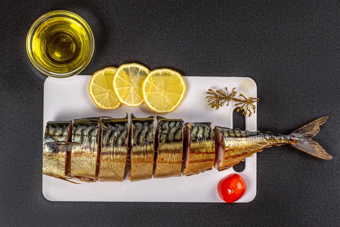 Smoked Mackerel with Lemon and Tomato on Cutting Board