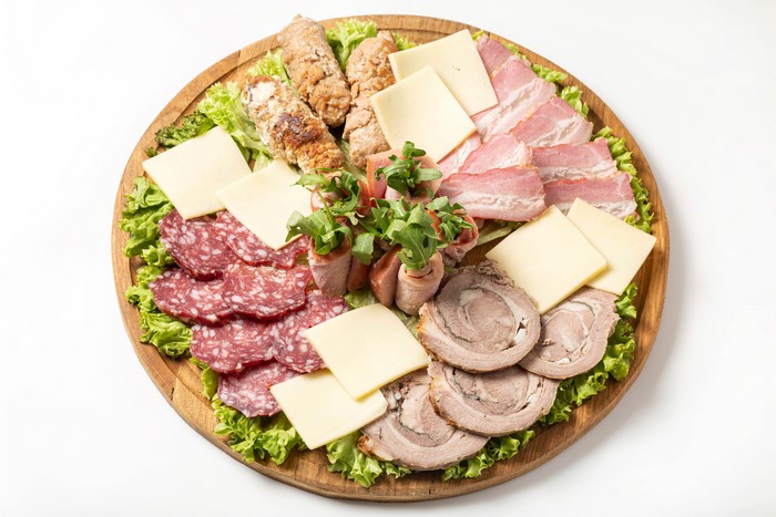 Meat and cheese platter with bread and lettuce