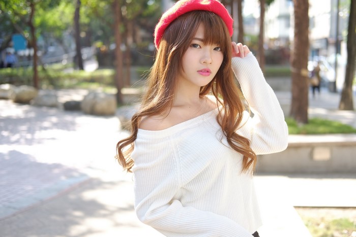 Asian woman with brown hair wearing a red beret