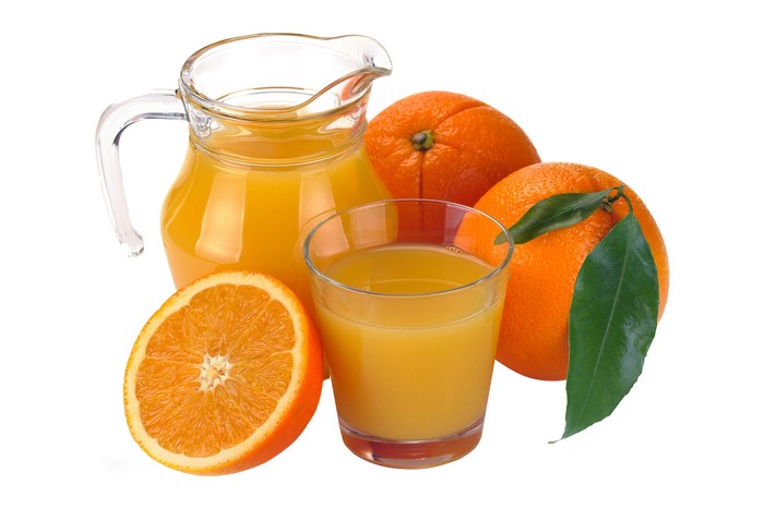 Orange juice in a jug and glass with oranges