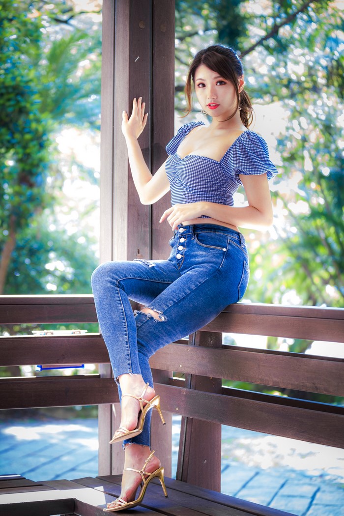 Asian Woman Sitting Wearing Jeans and Blouse