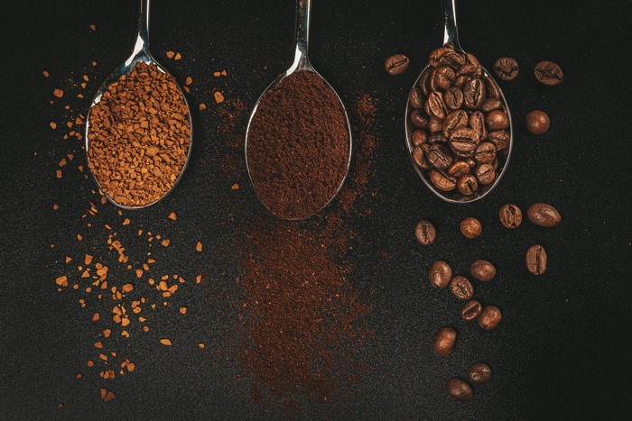Three spoons with coffee: instant, ground, and beans