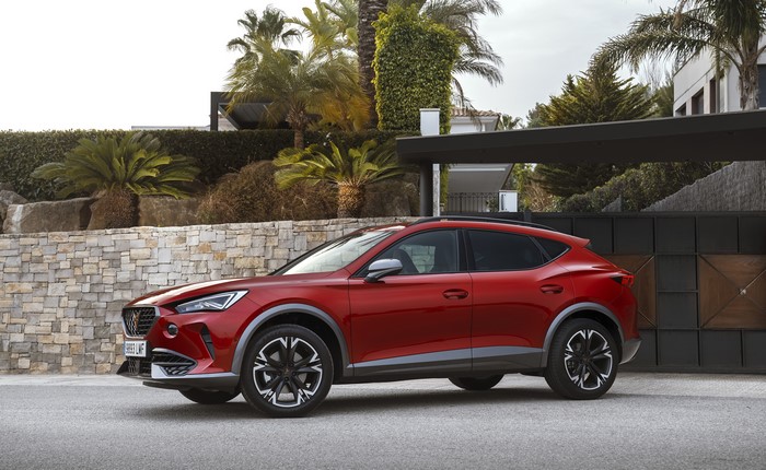 Red Cupra Crossover parked near a modern house