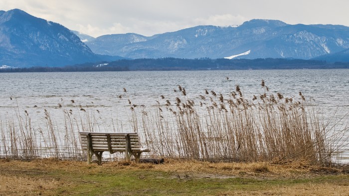 Bench by a lake with mountains in Bavaria, Germany