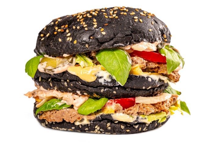 Double black hamburger with sesame seeds and vegetables