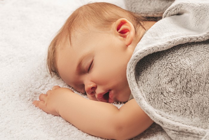 Baby sleeping on a white blanket