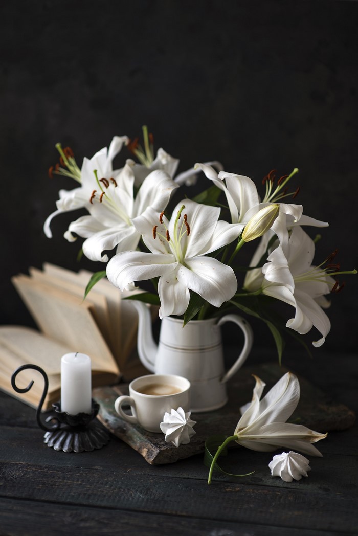 Still life with white lilies, coffee, and candle