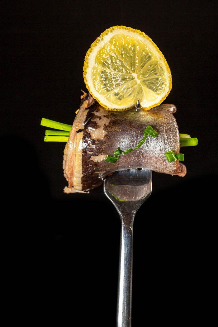 Smoked fish with lemon and chives on a fork