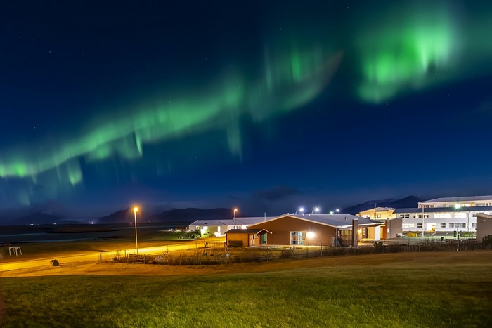 Aurora Borealis over houses in Iceland at night
