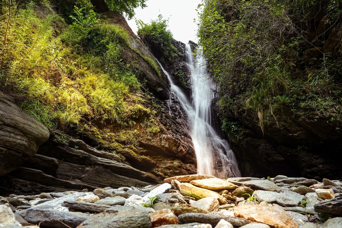 Waterfall cascading over rocks with surrounding greenery
