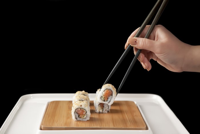 Sushi being picked up with chopsticks