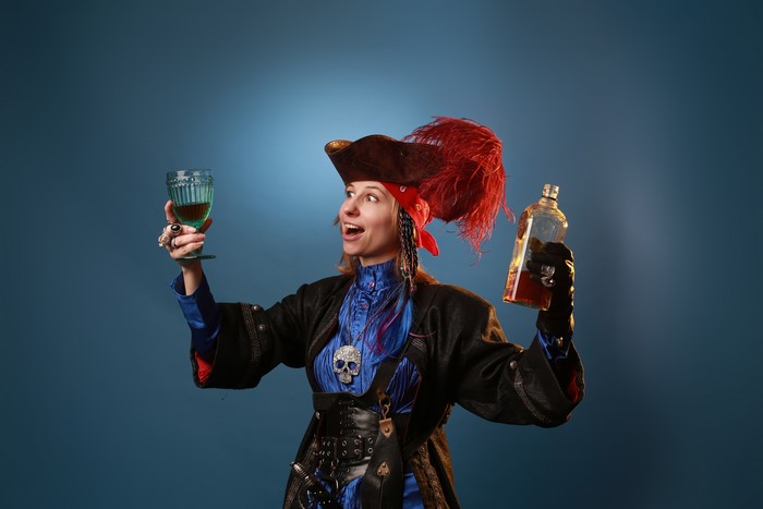 Pirate with a hat, feathers, glass, and bottle