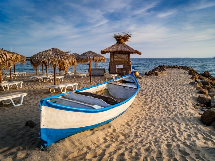 Beach with umbrellas, sunloungers, and a boat in Bulgaria