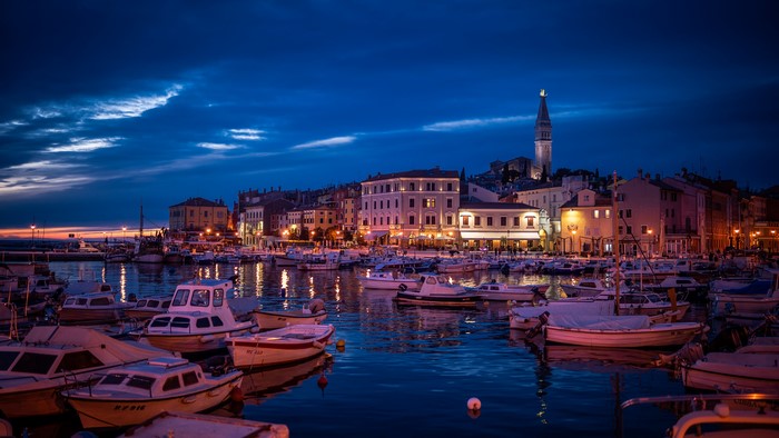 Boats docked in a harbor at dusk in Rovinj, Croatia