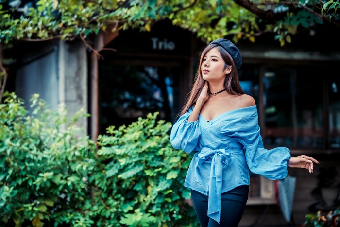 Asian woman wearing a blue blouse and beret
