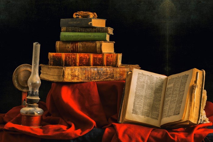 Still-life with old books and oil lamp