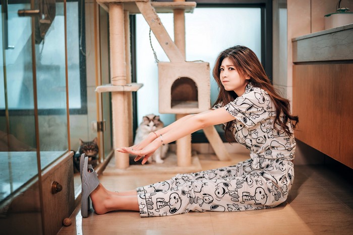 Asian woman in Snoopy pajamas with cats