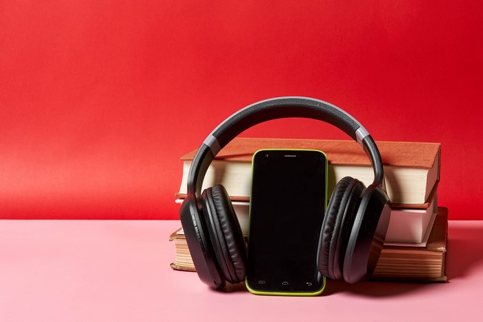 Headphones, Smartphone, and Books on Red Background
