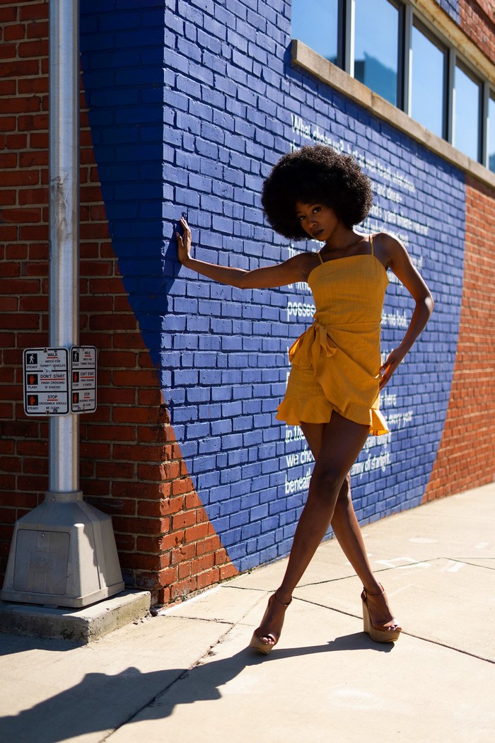 Janae Fulton posing by a brick wall