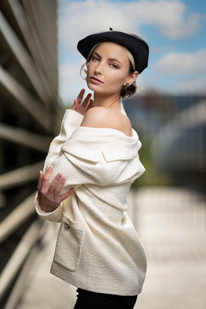 Alena wearing a beret and off-the-shoulder jacket