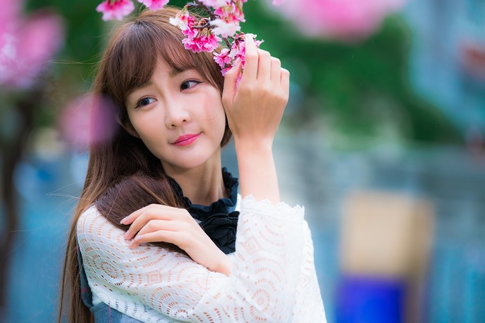 Asian woman with brown hair and pink flowers