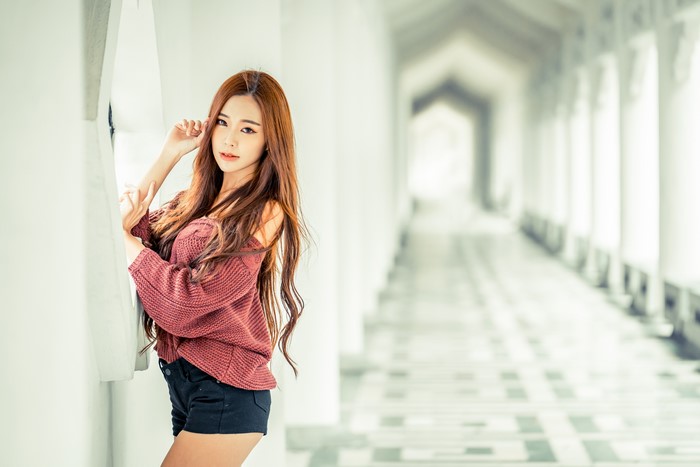 Asian woman with brown hair wearing a sweater and shorts