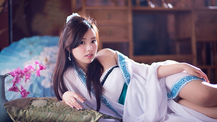 Brunette girl lying down with orchids