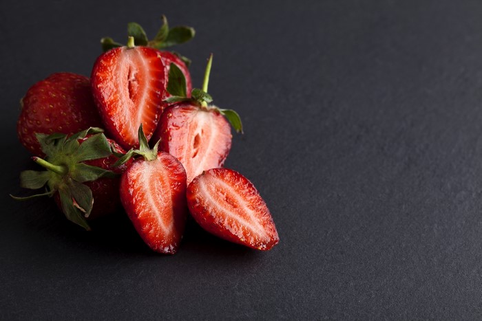Strawberries sliced on a dark background
