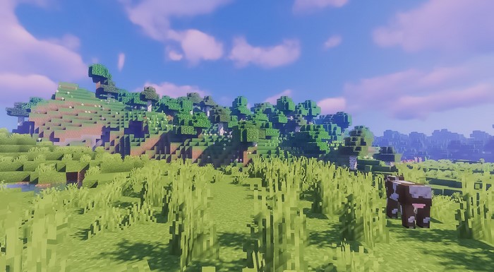 Minecraft landscape with trees, hills, and a cow
