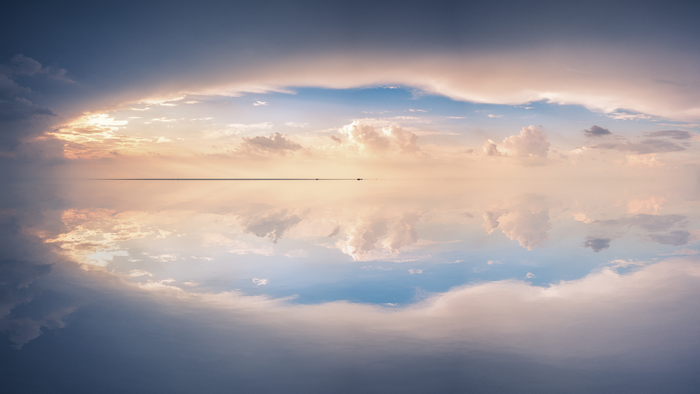 Mirror image of clouds reflecting on a calm body of water