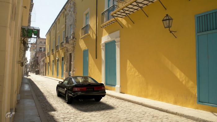 Black car on a cobblestone street in a city