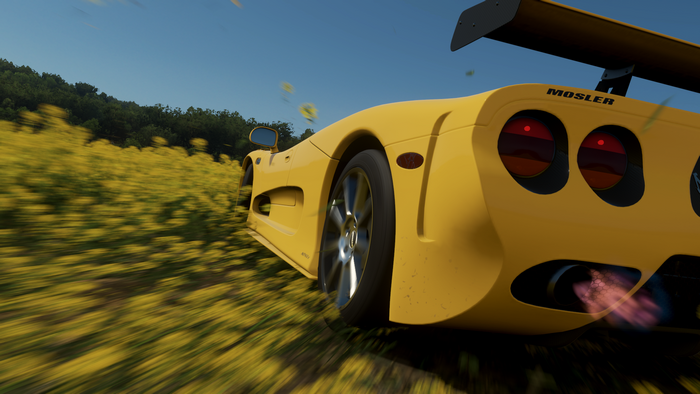 Yellow Mosler MT900 driving through a field in Forza Horizon 4