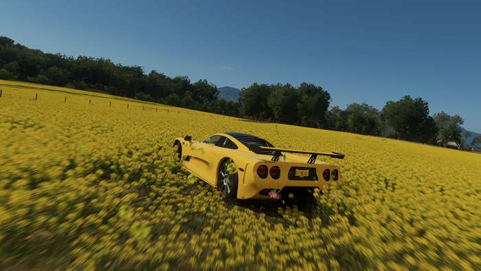 Yellow Mosler MT900 driving through a field in Forza Horizon 4