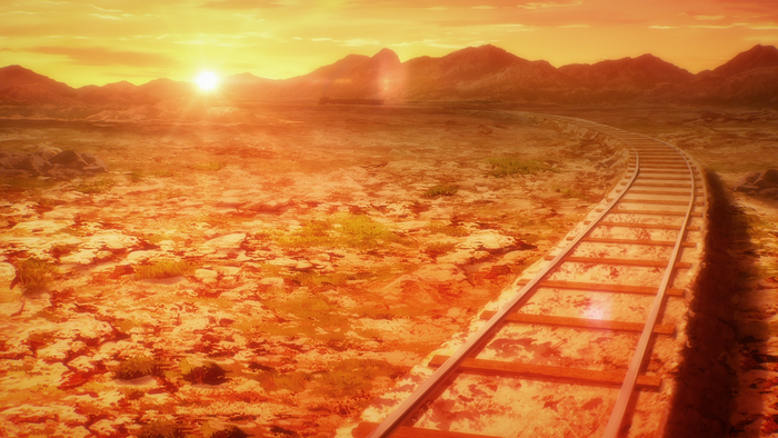 Train tracks in a desert landscape at sunset