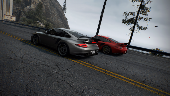 Two Porsche cars on a mountain road in Need for Speed: Hot Pursuit