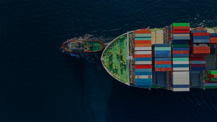 Container ship and tugboat sailing on the sea