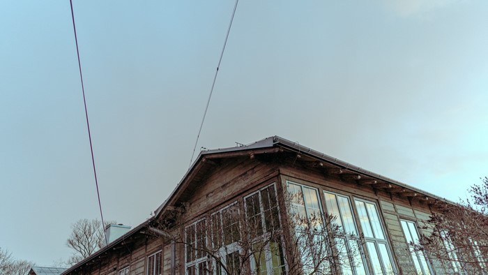 Wooden building with large windows and power lines