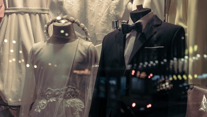 Wedding attire on mannequins in a shop window at night