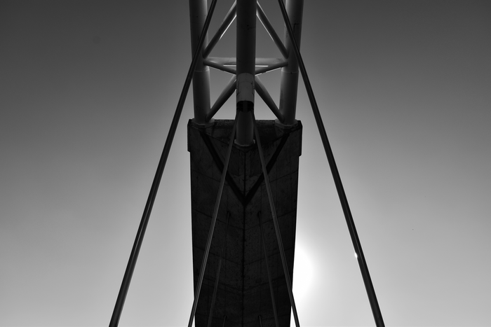 Monochrome abstract of bridge structure against gradient sky
