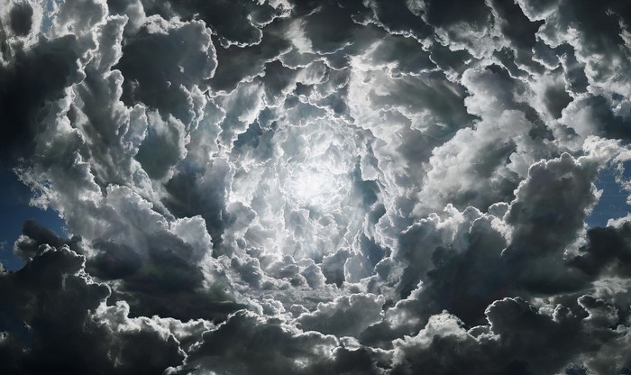 Sunlight shining through a swirling vortex of dramatic clouds