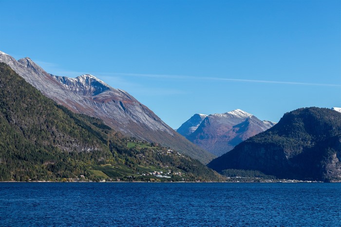 Snow-capped mountains over a blue lake and forest