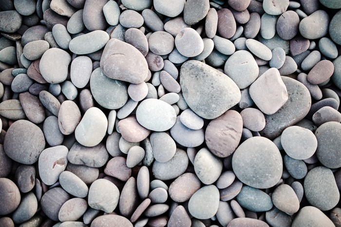 A pile of smooth, rounded stones of various sizes and colors.