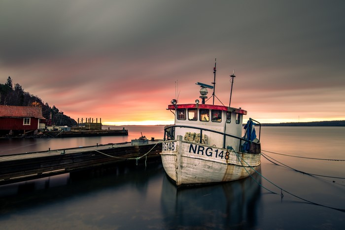 Boat NRG148 docked at pier during sunset