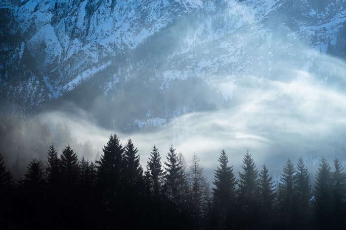 Snowy mountains and foggy forest landscape