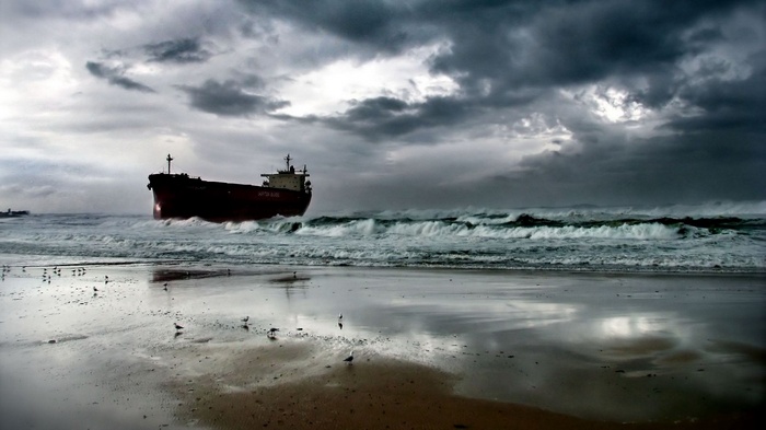 Ship grounded on beach during stormy weather
