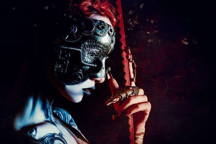 Woman in steampunk mask with red sword