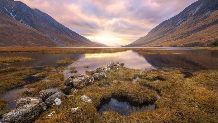 Valley lake with mountains and sunset sky