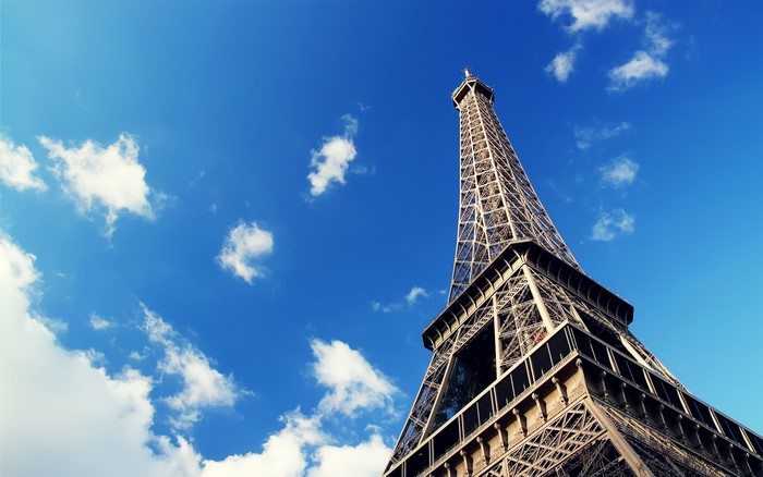 Eiffel Tower against a blue sky with clouds