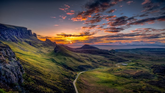 Sunrise over mountains and valleys with a winding road